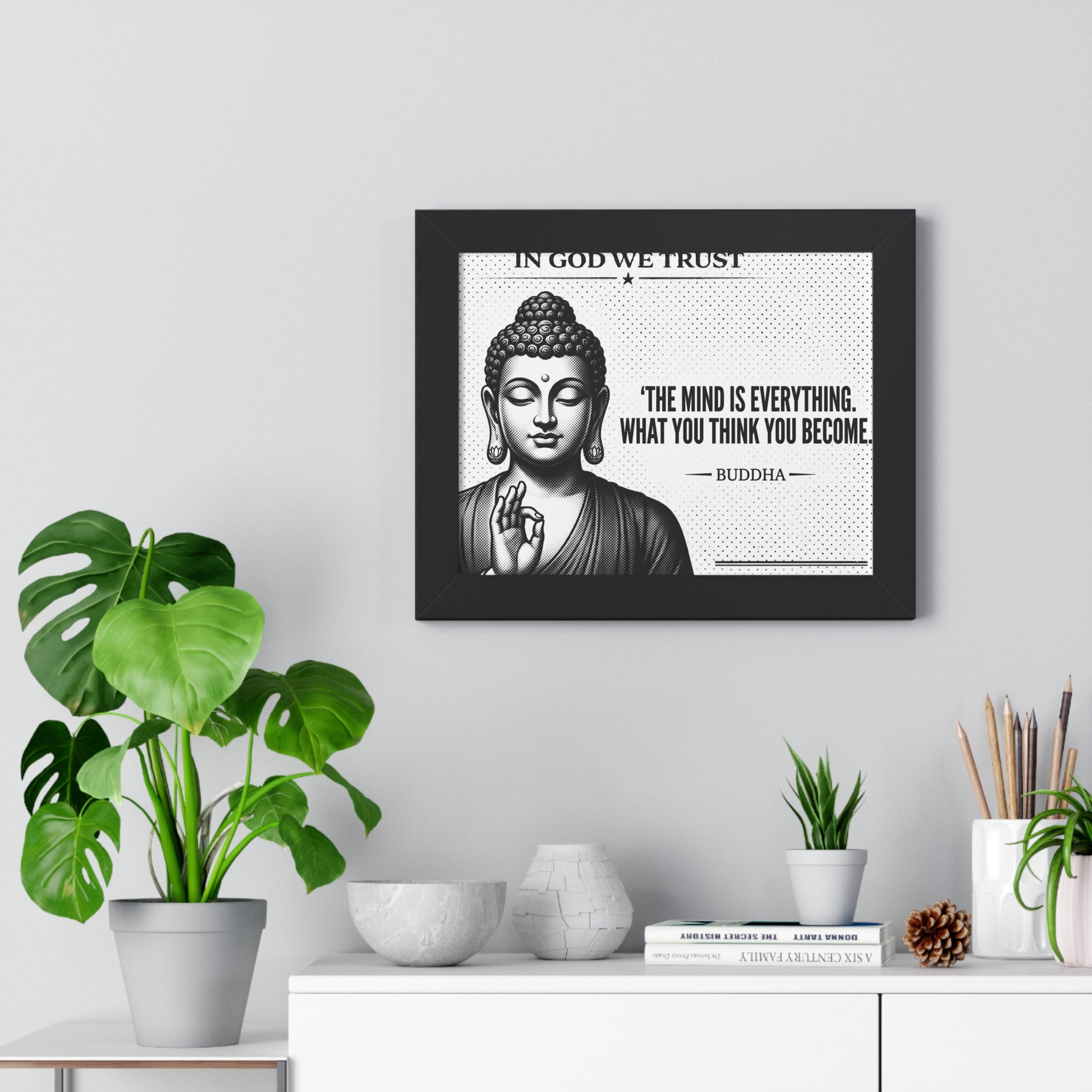 Framed Buddha poster with motivational quote on a wall with plants and decor.