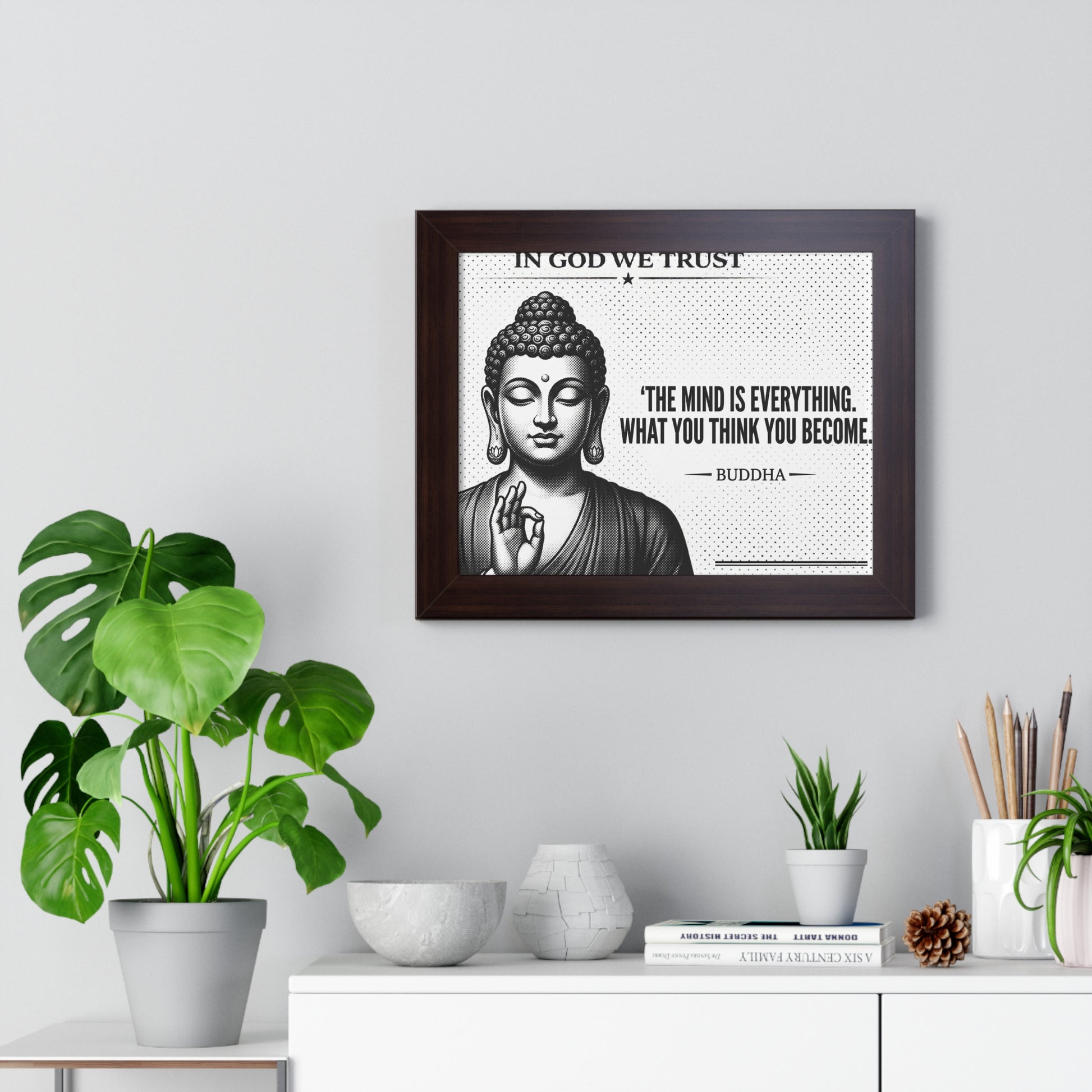 Framed Buddha poster with motivational quote on a wall with plants and decor.