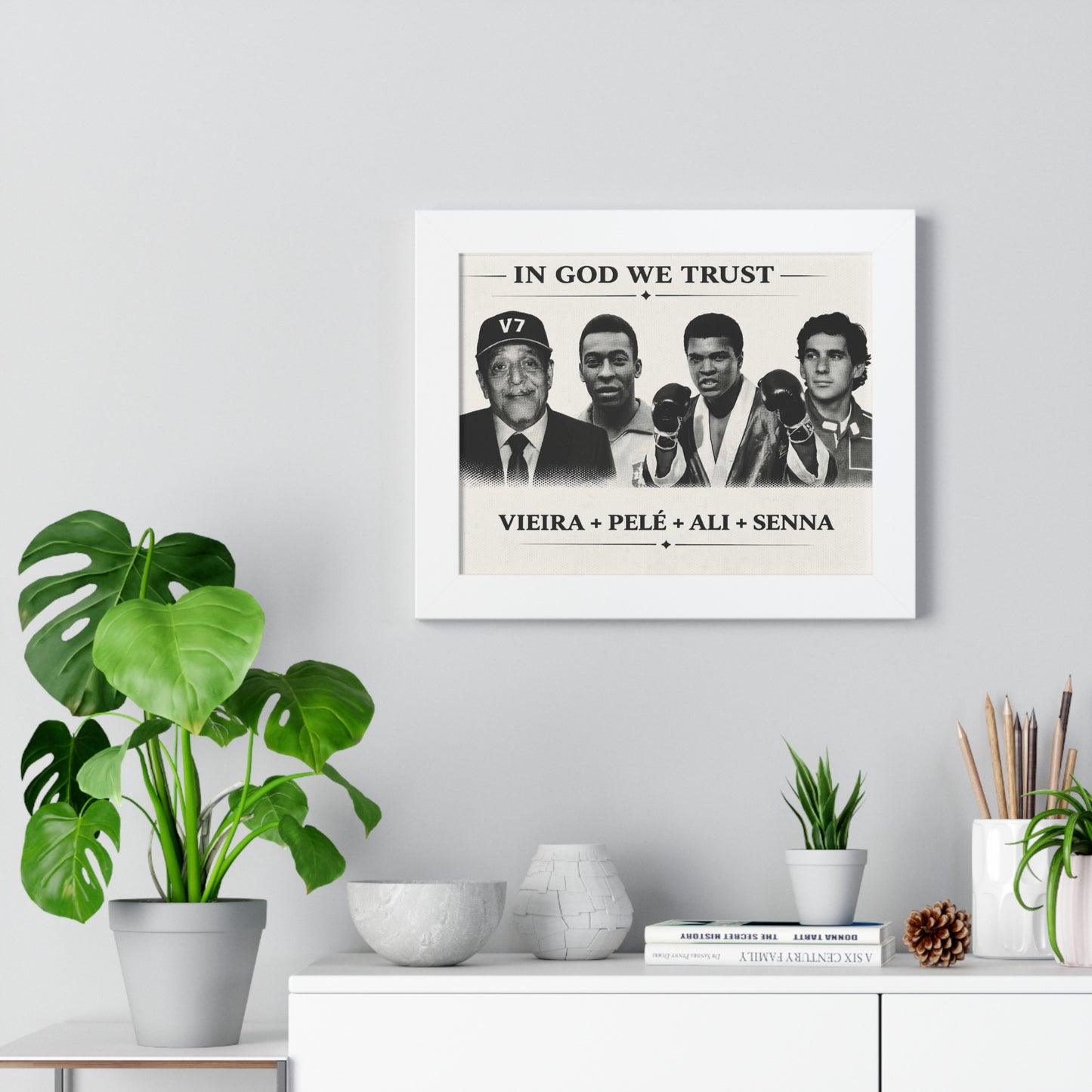 Framed artwork with a portrait of four individuals on a wall above a white cabinet with decorative items.