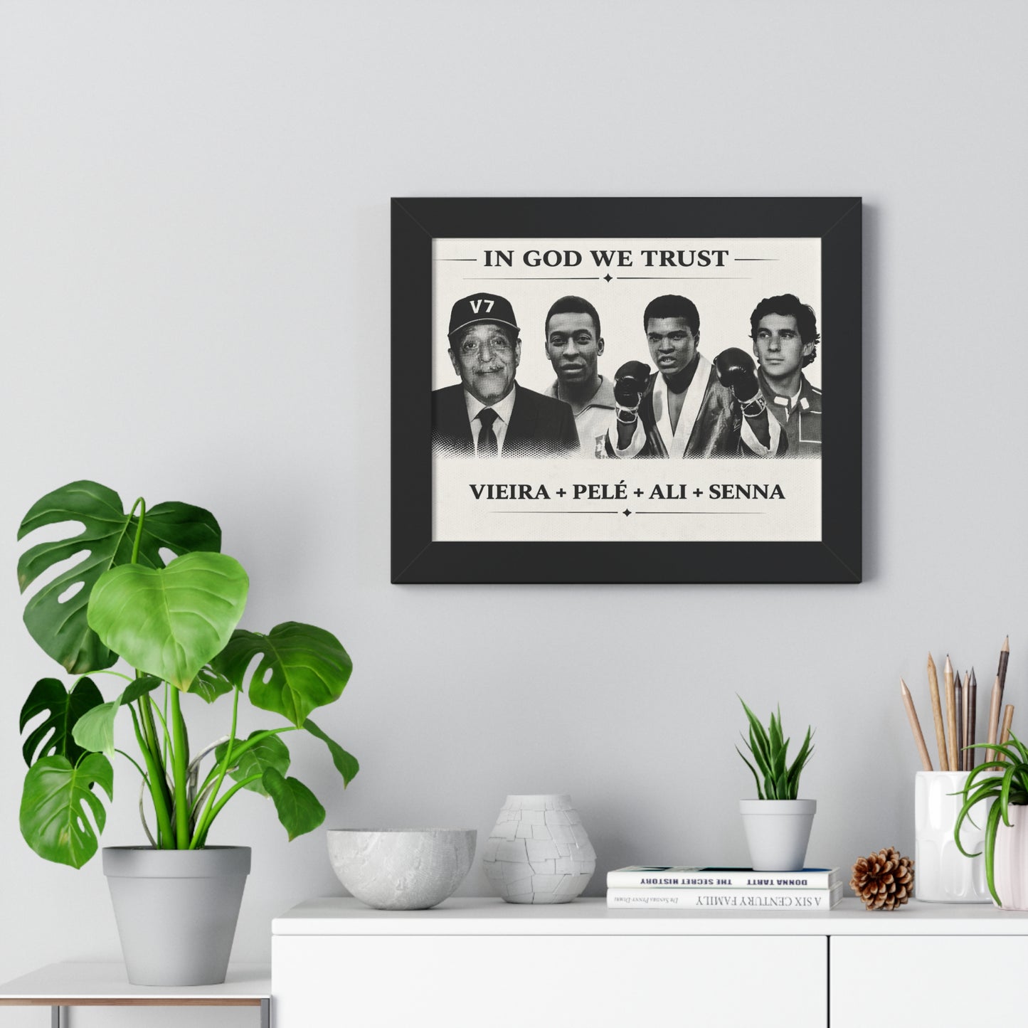 Framed poster with images of famous people on a wall above a white cabinet with decorative items.