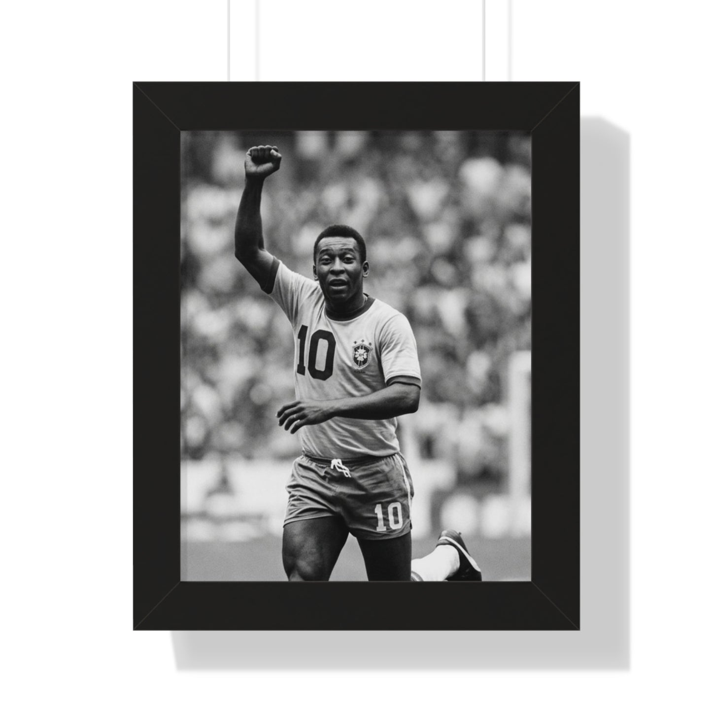 Framed black and white photo of a soccer player celebrating with a raised fist.