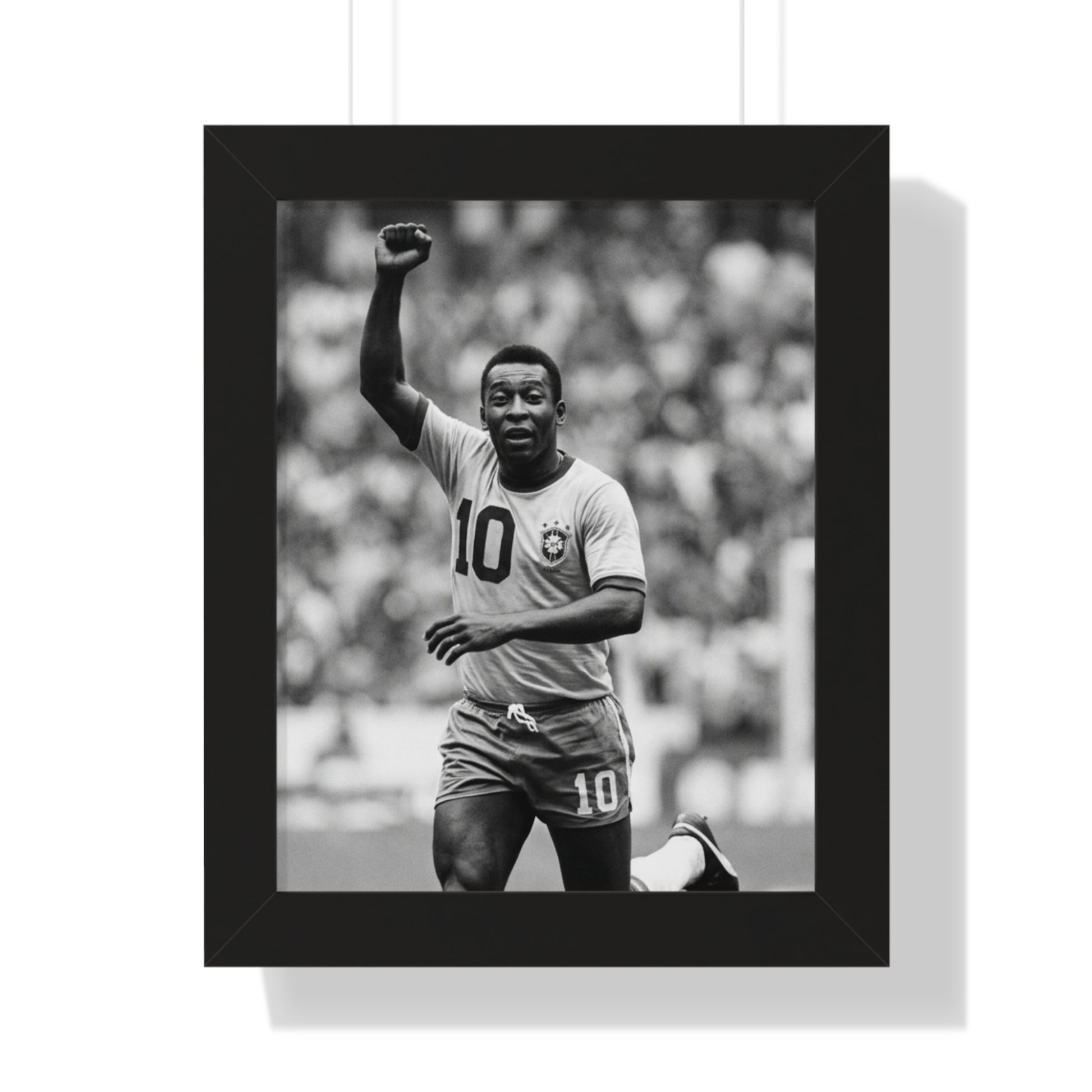 Framed black and white photo of a soccer player celebrating with a raised fist.