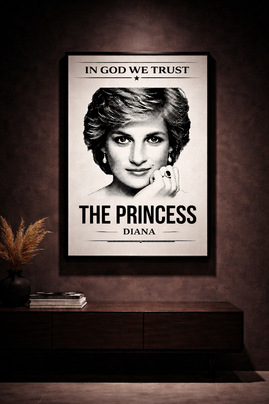 Framed poster of a portrait with 'In God We Trust' above and 'The Princess Diana' below on a dark wall.