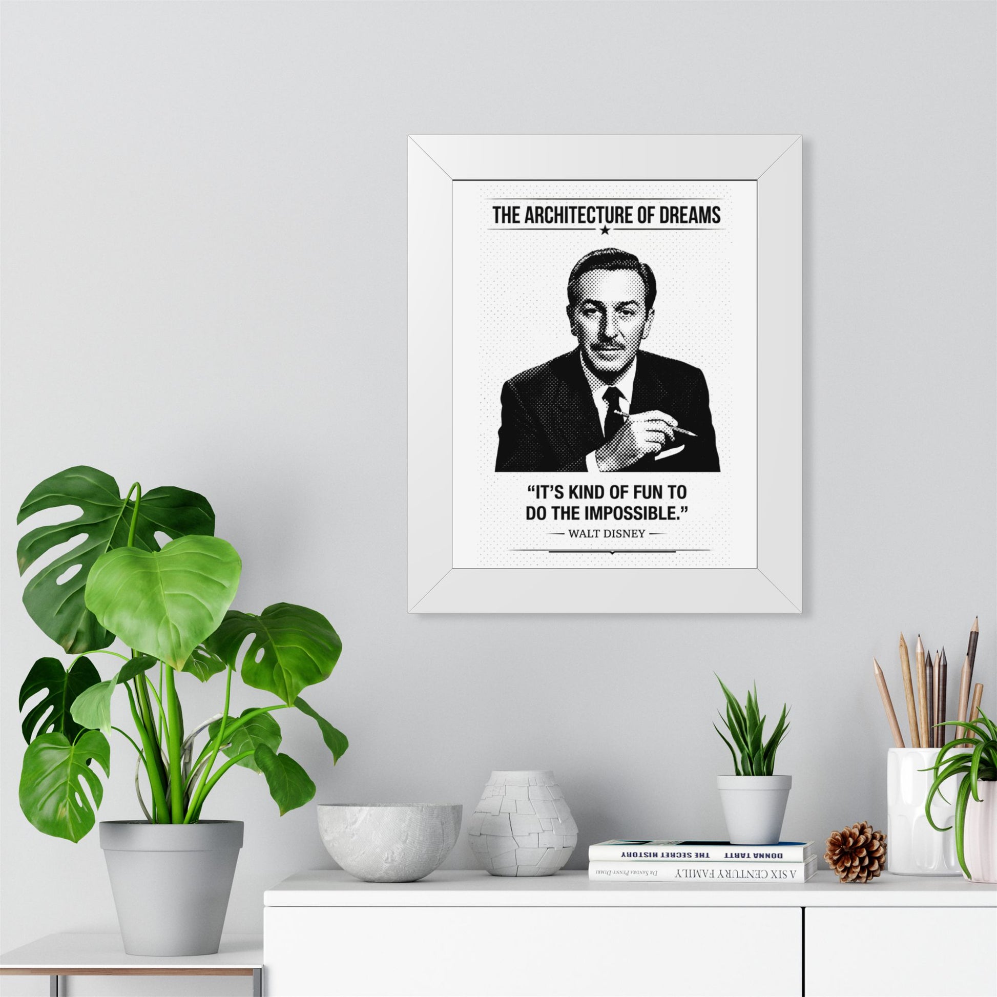 Framed ART with a quote by Walt Disney in a home office setting with plants and decor.