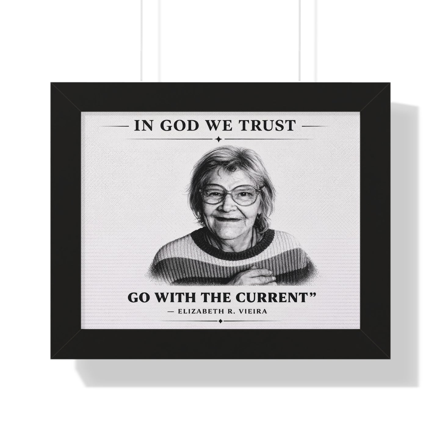Framed print with a black and white portrait of a woman and text 'In God We Trust, Go with the Current - Elizabeth R. Vieira' on a white background.